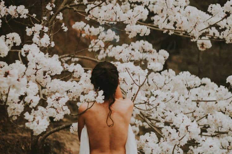 A girl in front of a blossomed tree