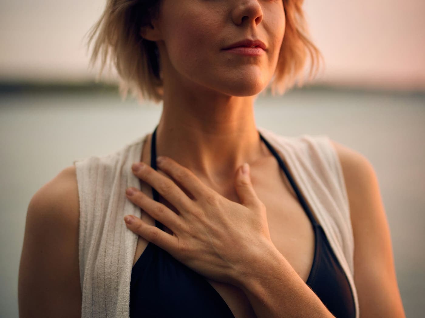 A parent pausing with a hand on their heart in a moment of self-compassion