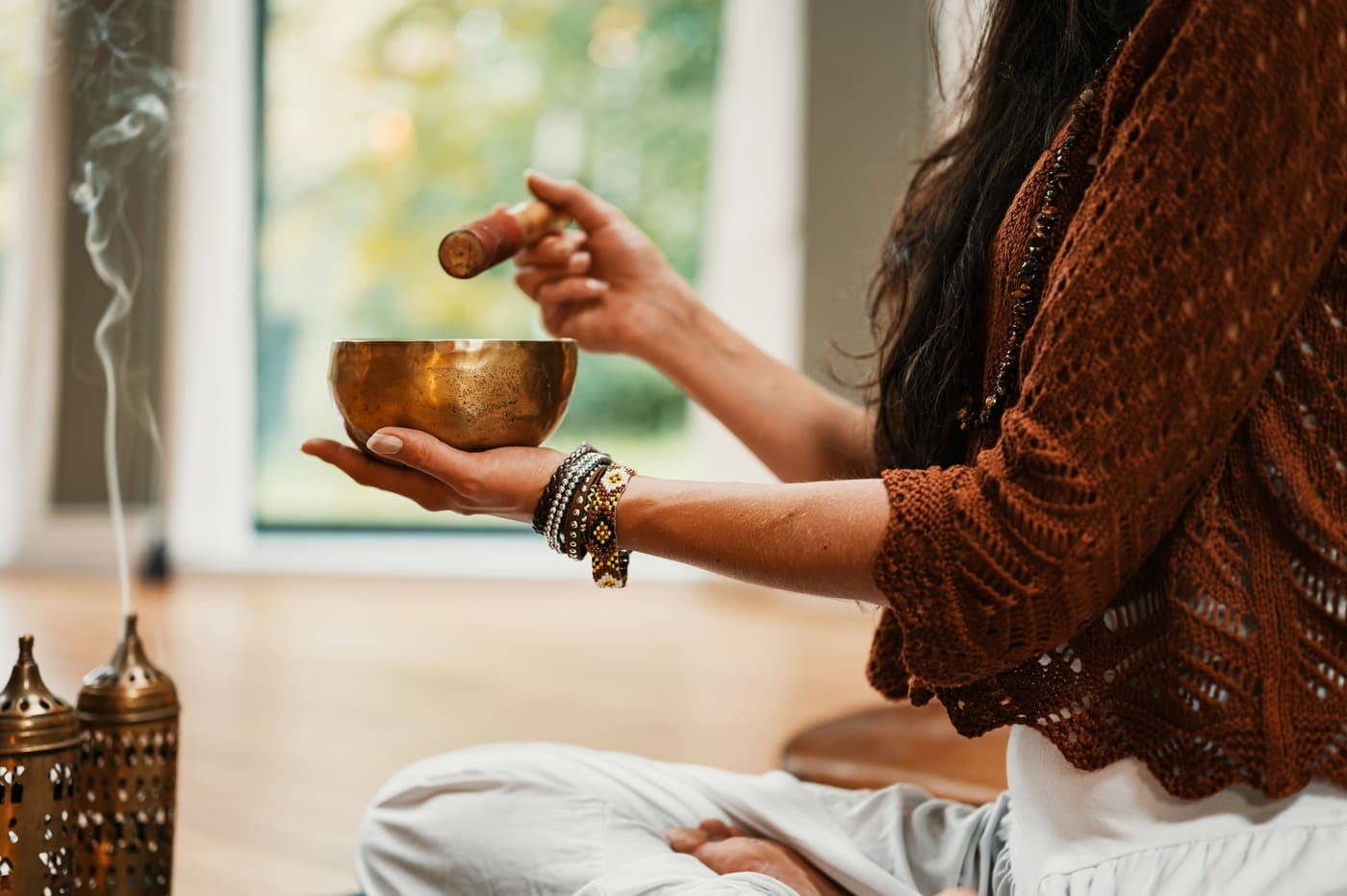 A teacher striking a singing bowl — a sensory anchor for memory-care meditation