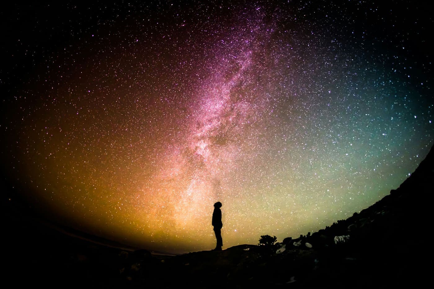 A teenager standing under a starry night sky, practicing mindful awareness of nature