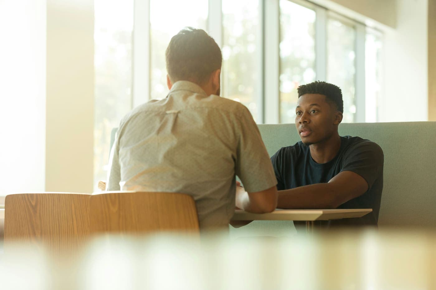 A meditation teacher talking with an employee during a workplace meeting